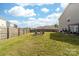 Expansive backyard with a fire pit, fenced perimeter, offering ample space for outdoor activities and entertaining at 132 Moores Branch Rd, Mount Holly, NC 28120