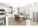 Dining area with wood table, modern light fixture, and view into the open kitchen with white cabinets at 132 Moores Branch Rd, Mount Holly, NC 28120