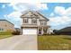 Charming two-story home with a two car garage, a well-manicured lawn, and a cozy front porch at 132 Moores Branch Rd, Mount Holly, NC 28120