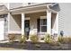 Charming front porch with a welcoming door, white rocking chairs, and manicured landscaping, enhancing curb appeal at 132 Moores Branch Rd, Mount Holly, NC 28120