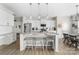 Contemporary kitchen features white cabinets, granite counters, an island with bar seating, and open access to the dining area at 132 Moores Branch Rd, Mount Holly, NC 28120