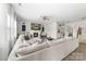 Spacious living room with a large white sofa, fireplace, shiplap accent wall, and wood-look flooring throughout at 132 Moores Branch Rd, Mount Holly, NC 28120