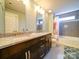Bathroom features double sinks with granite counters, wood cabinets, and tile flooring at 1421 Lyon Ct, Charlotte, NC 28205