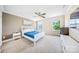 Bright bedroom with a white bed frame, a ceiling fan, and large windows overlooking the neighborhood at 1421 Lyon Ct, Charlotte, NC 28205