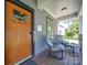 Inviting front porch features a wood door, grey siding and furniture, creating a welcoming outdoor space at 1421 Lyon Ct, Charlotte, NC 28205