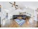 Bright living room with hardwood floors, a ceiling fan, and an open staircase at 1421 Lyon Ct, Charlotte, NC 28205