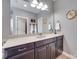 Bathroom features a double vanity with granite countertops, decorative lighting and wall mirror at 1446 Cilantro Ct, Tega Cay, SC 29708