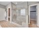 Beautifully tiled shower with glass doors in light and airy primary bath at 1446 Cilantro Ct, Tega Cay, SC 29708