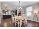Well-lit dining area featuring hardwood floors and a view into the modern kitchen at 1446 Cilantro Ct, Tega Cay, SC 29708