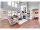 Open-concept living room with a fireplace and large windows at 1446 Cilantro Ct, Tega Cay, SC 29708