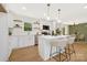 Modern kitchen featuring white cabinets, stainless steel appliances, an island with bar stools, and hardwood floors at 145 Burton Hills Cir, Gastonia, NC 28054