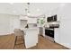 Modern kitchen featuring white cabinets, stainless steel appliances, an island with bar stools, and hardwood floors at 145 Burton Hills Cir, Gastonia, NC 28054