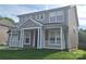 Two-story house featuring a welcoming front porch with white columns and a well-manicured lawn at 15326 Carrington Ridge Dr, Huntersville, NC 28078
