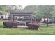 Community gazebo with wooden pergola and swing seating surrounded by manicured shrubs on a grassy lawn at 15326 Carrington Ridge Dr, Huntersville, NC 28078