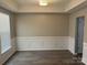 Elegant living room featuring a tray ceiling, paneled walls, light hardwood floor, and contemporary lighting at 15326 Carrington Ridge Dr, Huntersville, NC 28078