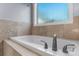 Bathroom featuring a soaking tub, tiled walls, and window at 1618 33Rd Ne Ave # 1, Hickory, NC 28601