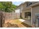 Backyard with a small patio area, wooden fence, and sliding glass door leading into the home at 1720 Forest Side Ln, Charlotte, NC 28213