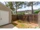 Fenced backyard with a storage shed and a gate leading to the adjacent community at 1720 Forest Side Ln, Charlotte, NC 28213