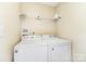 Laundry room including a washer and dryer set with a utility shelf above at 1720 Forest Side Ln, Charlotte, NC 28213