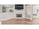 Cozy living space featuring a fireplace, built-in shelves, and an open view into the modern kitchen at 17810 Half Moon Ln # L, Cornelius, NC 28031