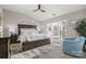 A spacious main bedroom features a ceiling fan, chair, and large windows that provides ample natural light at 17810 Half Moon Ln # L, Cornelius, NC 28031