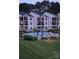 Beautiful condo building with a pool, lounge chairs, and outside seating, perfect for relaxing and enjoying the outdoors at 17810 Half Moon Ln # L, Cornelius, NC 28031