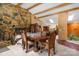 Dining area featuring a large stone fireplace, beamed ceilings, and a view into the kitchen at 189 Billy Jo Rd, Mooresville, NC 28117