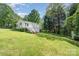 View of the home's backyard featuring mature trees and a large grassy area at 204 Myers St, Fort Mill, SC 29715