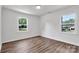 Bedroom features luxury vinyl flooring, a light, and two windows with outdoor views of the surrounding property at 205 Mcgregor Rd, Gastonia, NC 28056