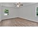 Bright bedroom features luxury vinyl flooring, a ceiling fan, and two windows overlooking outdoors at 205 Mcgregor Rd, Gastonia, NC 28056