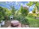 Landscaped backyard features a brick patio, garden, and a cozy area with white chair and fire pit at 2110 Cool Springs Ct, Kannapolis, NC 28083