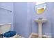 Powder room with pedestal sink, decorative mirror, and blue painted walls creating a calming space at 2110 Cool Springs Ct, Kannapolis, NC 28083