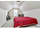 Attic bedroom features a red bed, neutral walls and carpet, and a window for natural light at 2110 Cool Springs Ct, Kannapolis, NC 28083