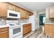 Functional kitchen with white appliances, wooden cabinets, and a stylish tiled backsplash, great for cooking at 2110 Cool Springs Ct, Kannapolis, NC 28083