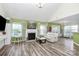 Spacious living room featuring a cozy fireplace, gleaming floors, and ample natural light from large windows at 2110 Cool Springs Ct, Kannapolis, NC 28083