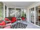Screened sunroom featuring multiple seating arrangements, a black and white carpet, and lots of green scenery at 2110 Cool Springs Ct, Kannapolis, NC 28083
