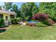 Lush backyard with a beautiful in-ground pool, manicured lawn and mature trees at 2153 Darian Way, Waxhaw, NC 28173