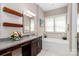 Elegant bathroom with granite counters, a tub, and decor shelving at 2153 Darian Way, Waxhaw, NC 28173
