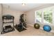 Well-lit exercise room with treadmill, weight machine, exercise ball, and ample natural light from a large window at 2153 Darian Way, Waxhaw, NC 28173