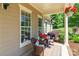 Cozy front porch featuring comfortable wicker seating, a side table, and charming hanging flower baskets at 2153 Darian Way, Waxhaw, NC 28173