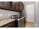Well-equipped laundry room with a washer, dryer, granite countertop, and matching overhead cabinets at 2153 Darian Way, Waxhaw, NC 28173