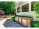 Well-equipped outdoor kitchen with a grill, cabinets, and stone accents, perfect for outdoor entertaining near the pool at 2153 Darian Way, Waxhaw, NC 28173