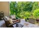 Outdoor patio area with comfortable wicker furniture, offering a relaxing space surrounded by lush greenery at 2153 Darian Way, Waxhaw, NC 28173