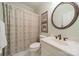 Well-lit bathroom features a large mirror, stylish fixtures, and neutral patterned shower curtain at 242 Beckham Ct, Charlotte, NC 28211