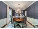 Chic dining room with navy wallpaper, a wooden table, and seating for six, a perfect space for sharing meals at 242 Beckham Ct, Charlotte, NC 28211