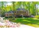 Charming brick home with lush green lawn, beautiful blooming flowers and mature trees at 242 Beckham Ct, Charlotte, NC 28211