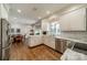 Well-lit kitchen with white cabinetry, marble countertops, stainless steel appliances, and hardwood floors at 242 Beckham Ct, Charlotte, NC 28211