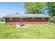 Grassy backyard with brick house and metal roof with basement walkout access at 3340 Wrenwood Dr, Newton, NC 28658