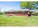 Brick house with metal roof and covered side porch with a spacious backyard at 3340 Wrenwood Dr, Newton, NC 28658