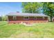 Brick house with metal roof in the backyard showing walkout basement entrance at 3340 Wrenwood Dr, Newton, NC 28658